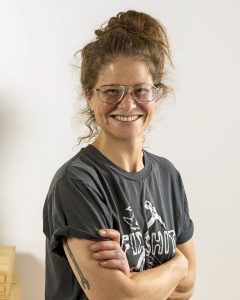 woman with crossed arms and glasses smiles