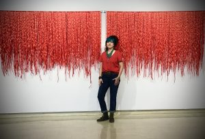 woman in front of wall of artwork