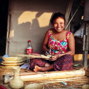 women sitting making a basket