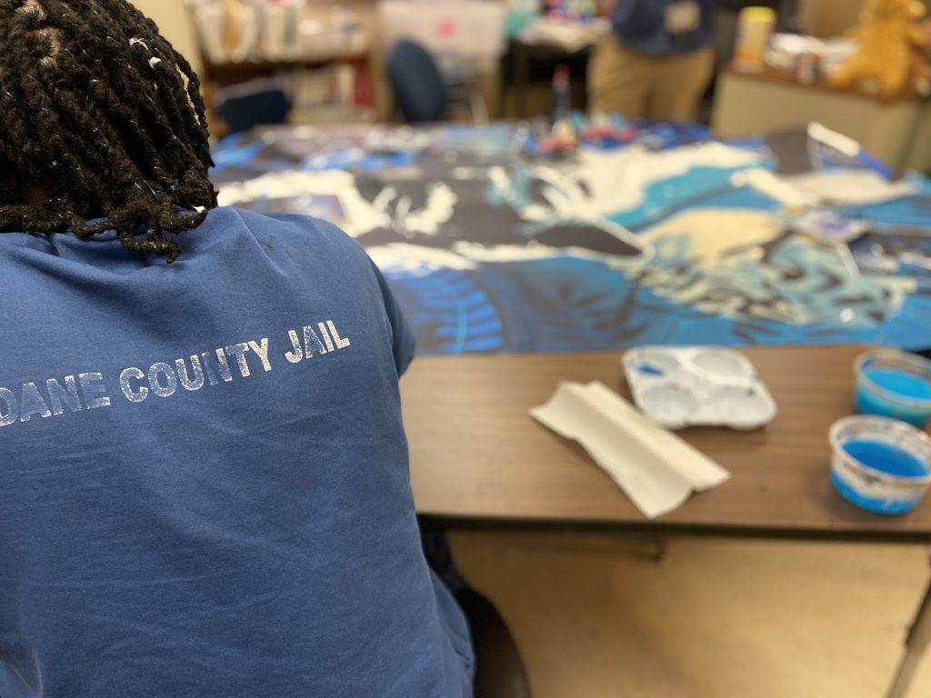 Teens working on mural artwork indoors