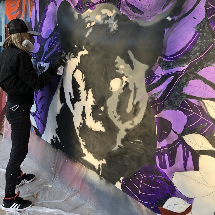 Artist painting black panther mural