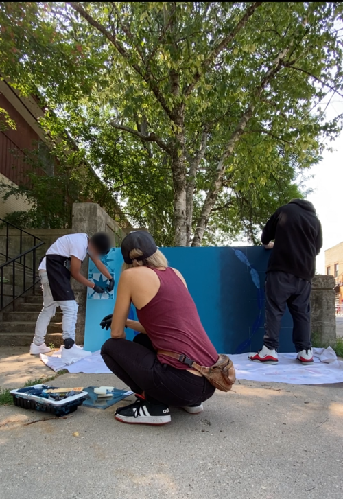 Teens working on mural outside