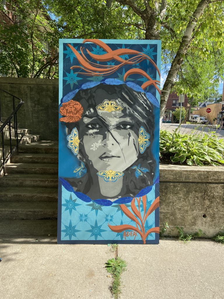 Image of finished mural depicting a face and swirls of blue and orange colors
