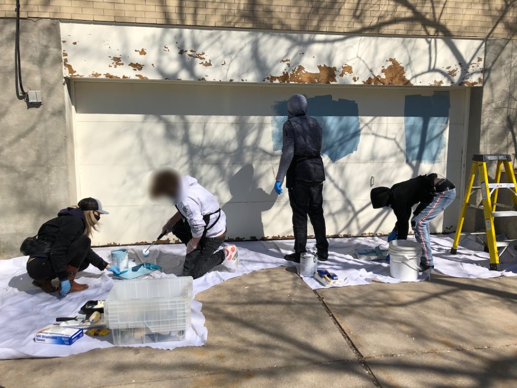 Teens working on mural outside
