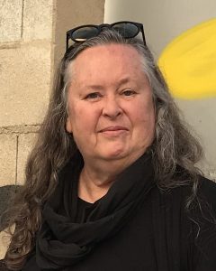 Image of photo of artist; long hair, sunglasses on top of her head