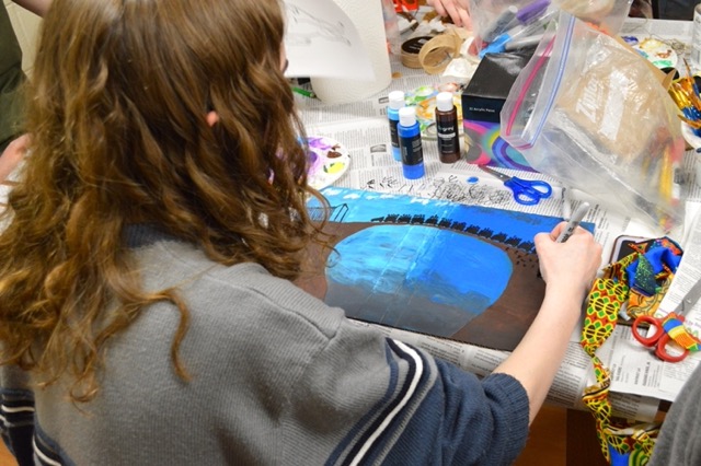Student creating cardboard book cover.