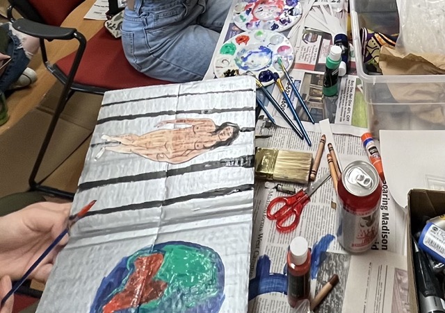 Student creating cardboard book cover.